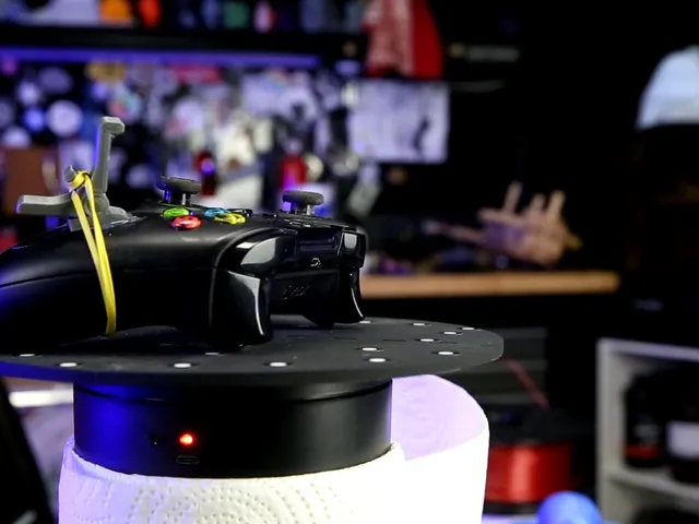 A black x-box controller with a grey 3D-printed addition attached with a yellow elastic.